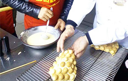 老師教導(dǎo)學(xué)員烘焙雞蛋仔